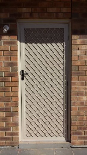 Security door installed on brick wall